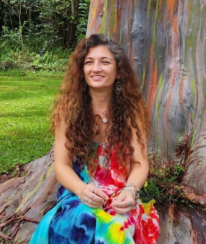 Juliana sitting in front of a rainbow eucalyptus